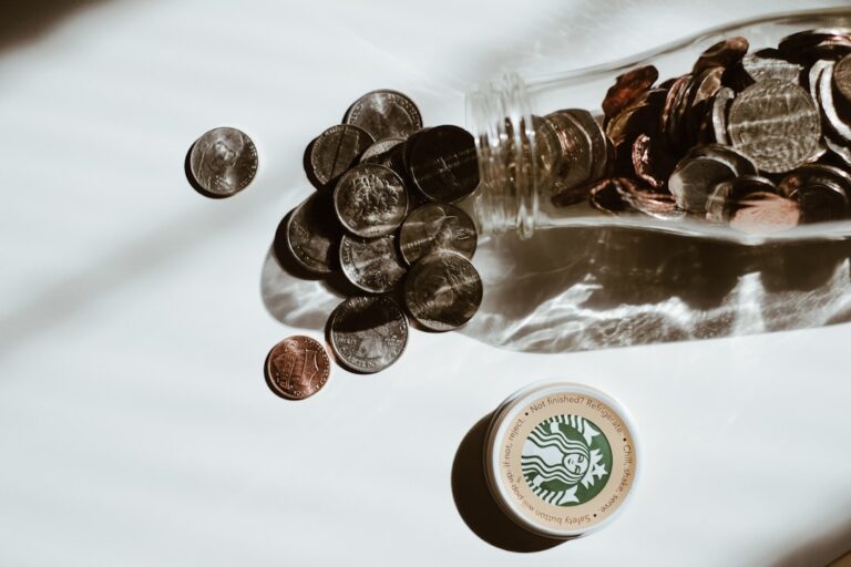 A glass jar filled with coins and cash representing how to save money on a low income