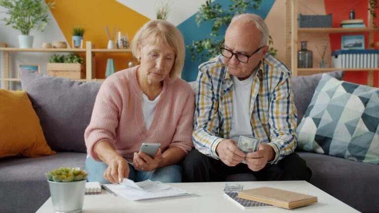 Person reviewing 401k contribution limits 2026 on a laptop with a notebook and coffee