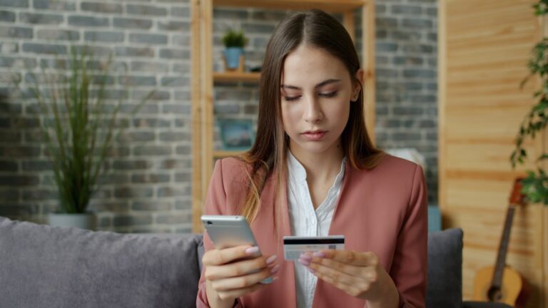 Person at kitchen table reviewing credit card statements, comparing balance transfer vs personal loan options