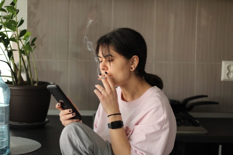 Woman counting cash at a kitchen table using the cash stuffing budget method to manage her monthly expenses