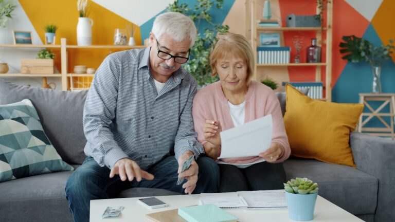 Person sitting at kitchen table reviewing financial documents while raising credit score 100 points