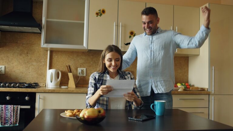 Person sitting at kitchen table reviewing debt statements and considering whether to cash out 401k to pay off debt