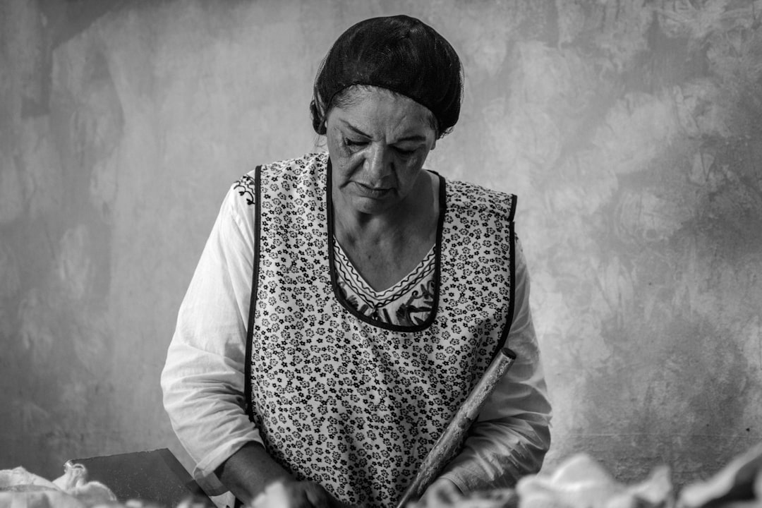 Woman reviewing Social Security paperwork and bills at a kitchen table, concerned about debt collectors garnishing her benefits