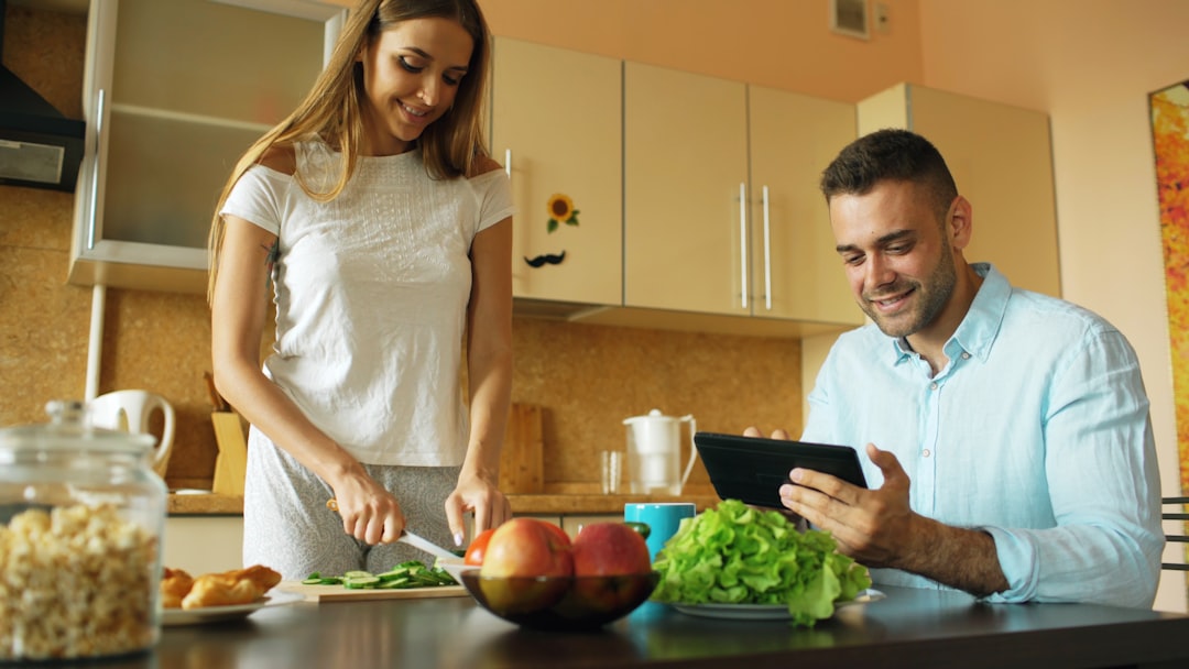Couple sitting at kitchen table reviewing finances together, illustrating money and marriage budgeting conversations