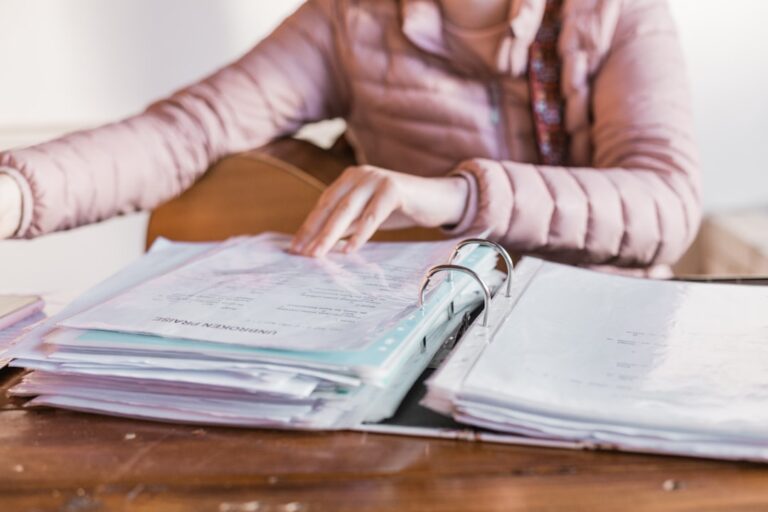 Person reviewing Roth conversion paperwork at a kitchen table, planning retirement finances