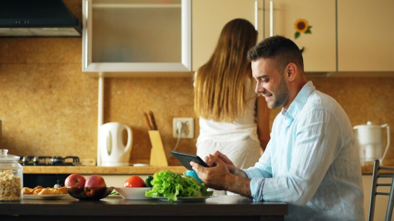 Person sitting at kitchen table reviewing bills and managing money after a job loss