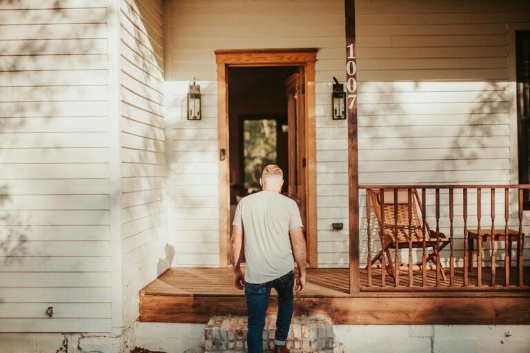Family sitting on front porch of home, representing homeownership statistics and the dream of buying a house in 2026