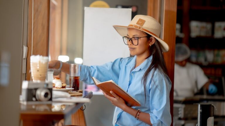 Woman reviewing medical bills and financial paperwork at kitchen table, planning her medical debt retirement strategy