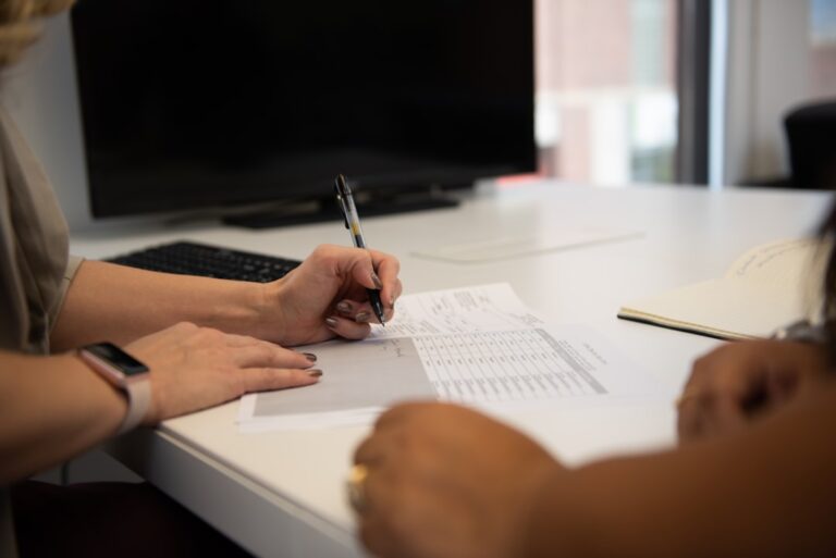 Person reviewing asset allocation documents at a kitchen table, learning how to split investments between stocks and bonds
