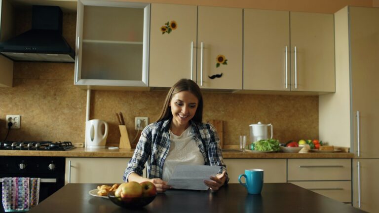 Person reviewing dollar cost averaging investments at kitchen table with coffee and notebook
