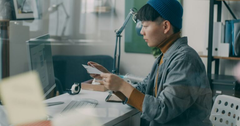 A person reviewing their paycheck and 401k match contributions while managing debt payments