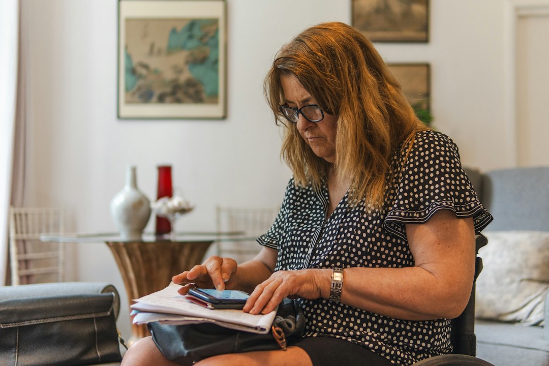 Woman sitting at kitchen table reviewing credit card statements and bills — your credit score complete guide